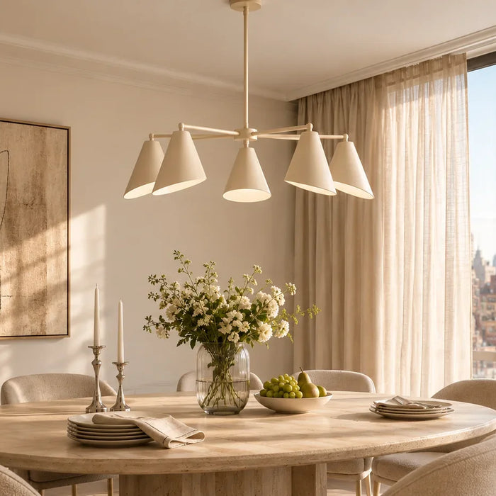 five-light cream chandelier in a modern New York condo dining room with beige curtains, warm neutral decor, and sunny morning lighting