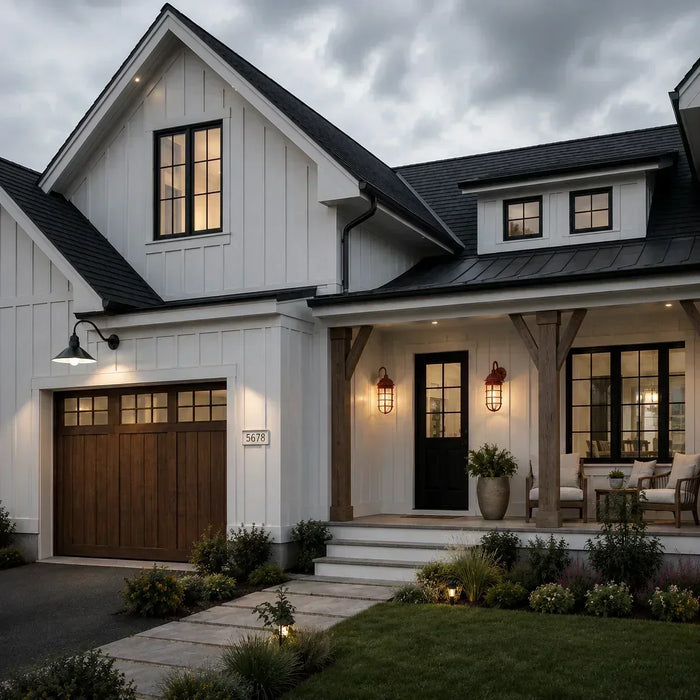 Classic contemporary home exterior on a cloudy afternoon, with warm wall lights and porch fixtures glowing against cool gray skies, creating realistic amber illumination and soft ambient shadows.