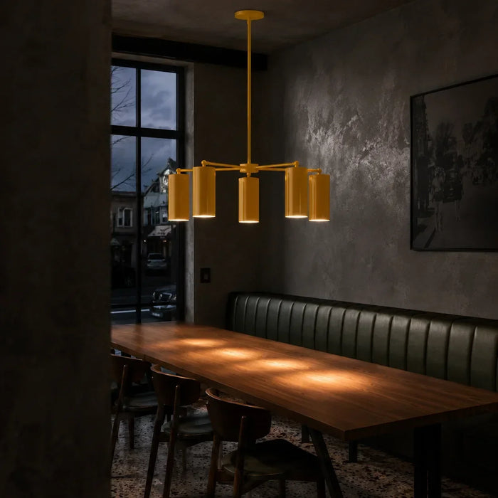 Yellow modern chandelier with multiple cylindrical shades above a dining table