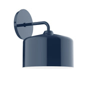 Navy wall sconce with round backplate and cylindrical shade on curved arm