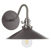 Bronze wall sconce with round backplate, curved arm, bell shade, clear bulb