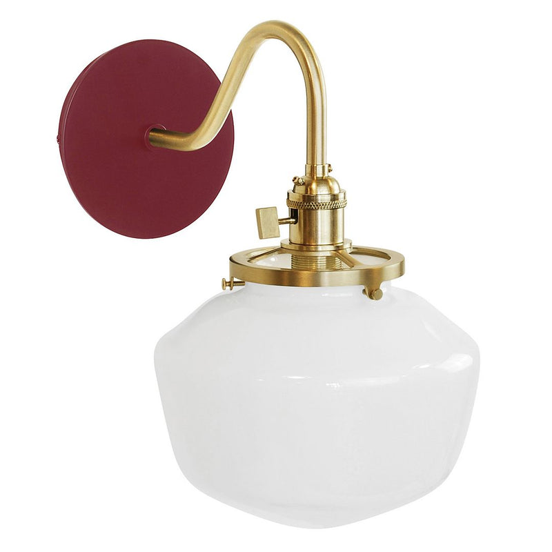 Barn red wall sconce with brushed brass arm and clear glass globe shade