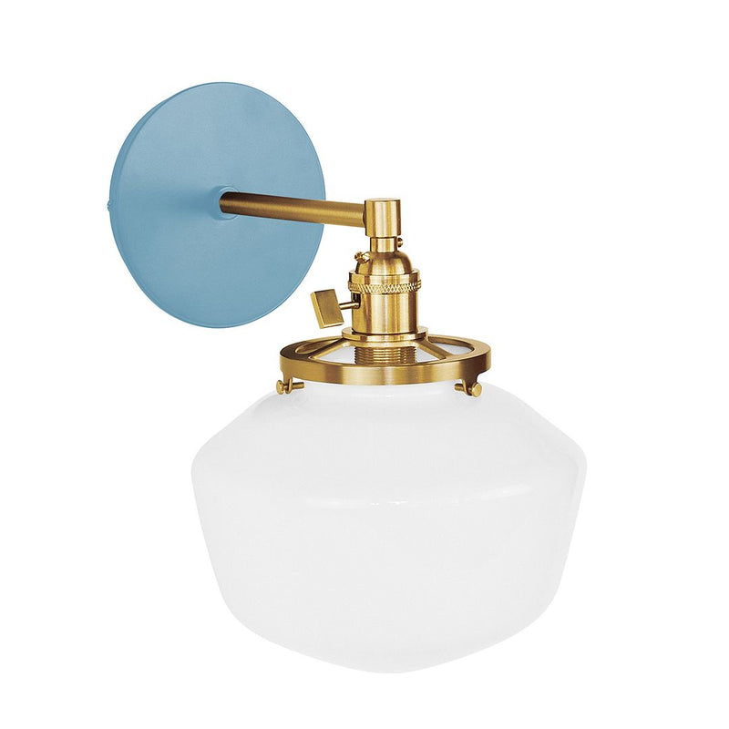 Light blue wall sconce with brushed brass mount and white glass dome shade.